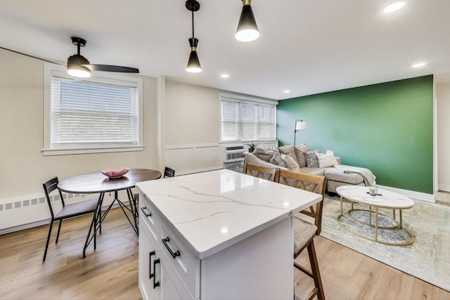 1333 W Touhy Ave Unit 102, Park Ridge, IL 60068 - kitchen featuring a kitchen island, light wood-type flooring, pendant lighting, white cabinets, and recessed lighting