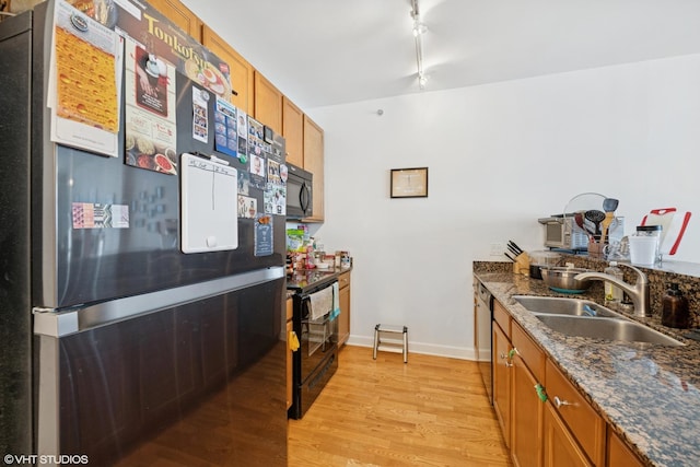 100 E 14th St Unit 1108, Chicago, IL 60605 - kitchen with black appliances, brown cabinets, light wood-style flooring, dark stone counters, and rail lighting
