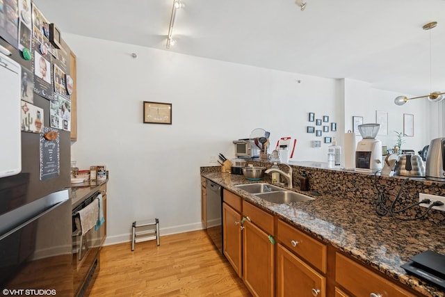 100 E 14th St Unit 1108, Chicago, IL 60605 - kitchen with black appliances, brown cabinetry, light wood-style flooring, dark stone countertops, and hanging light fixtures