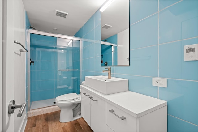 2113 N Clark St, Chicago, IL 60614 - bathroom featuring vanity, a stall shower, wood finished floors, and tile walls