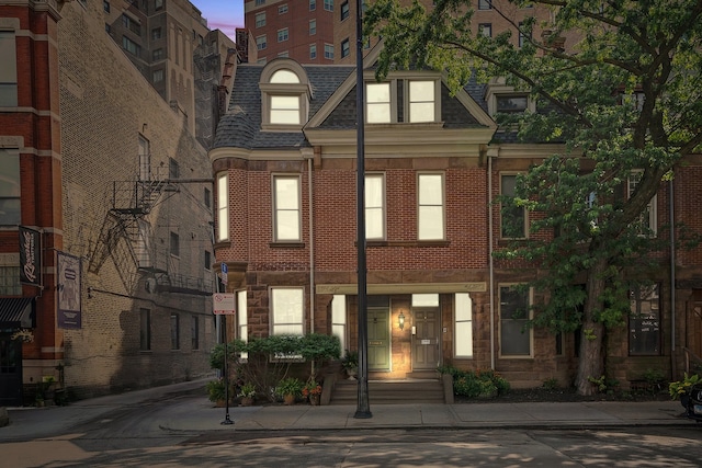 2113 N Clark St, Chicago, IL 60614 - view of property featuring mansard roof, brick siding, and roof with shingles