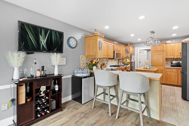 18049 Brittany Ln, Lansing, IL 60438 - kitchen with a peninsula, backsplash, light wood finished floors, recessed lighting, and a kitchen bar