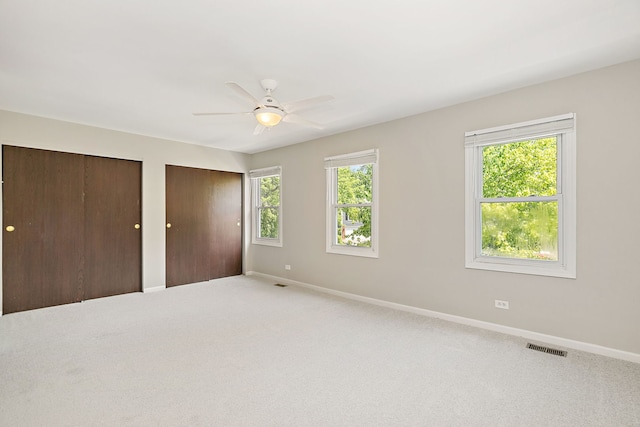 1479 Exeter Ct, Hoffman Estates, IL 60010 - unfurnished bedroom with multiple closets, carpet flooring, and a ceiling fan