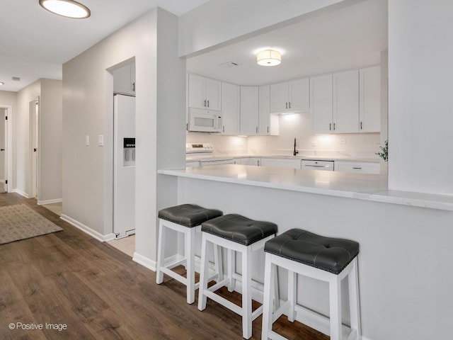 123 Acacia Cir Unit 414, Indian Head Park, IL 60525 - kitchen with light countertops, white cabinetry, white appliances, and a breakfast bar