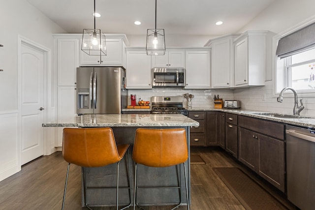 806 Cole Ln, Mahomet, IL 61853 - kitchen featuring appliances with stainless steel finishes, a center island, dark wood-type flooring, white cabinetry, and recessed lighting