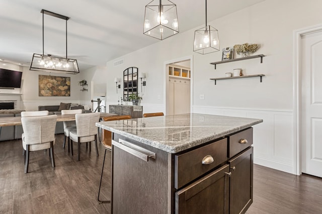 806 Cole Ln, Mahomet, IL 61853 - kitchen featuring dark brown cabinets, wainscoting, open floor plan, dark wood-style floors, and hanging light fixtures