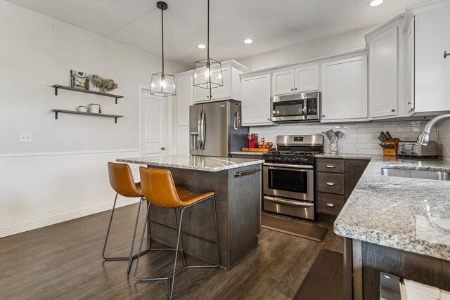 806 Cole Ln, Mahomet, IL 61853 - kitchen featuring appliances with stainless steel finishes, a kitchen island, dark wood-style flooring, tasteful backsplash, and recessed lighting