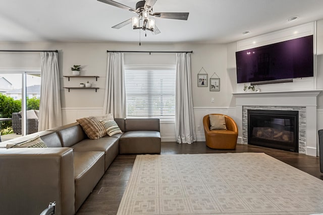 806 Cole Ln, Mahomet, IL 61853 - living room with a ceiling fan, a wainscoted wall, a glass covered fireplace, and dark wood-type flooring