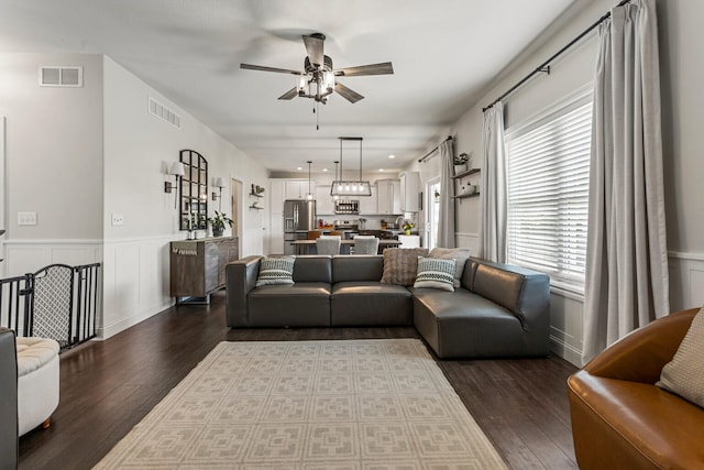 806 Cole Ln, Mahomet, IL 61853 - living area with a ceiling fan, dark wood finished floors, a wainscoted wall, and a decorative wall