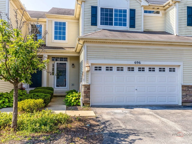 696 S Jade Ln, Round Lake, IL 60073 - multi unit property featuring an attached garage, stone siding, driveway, and roof with shingles