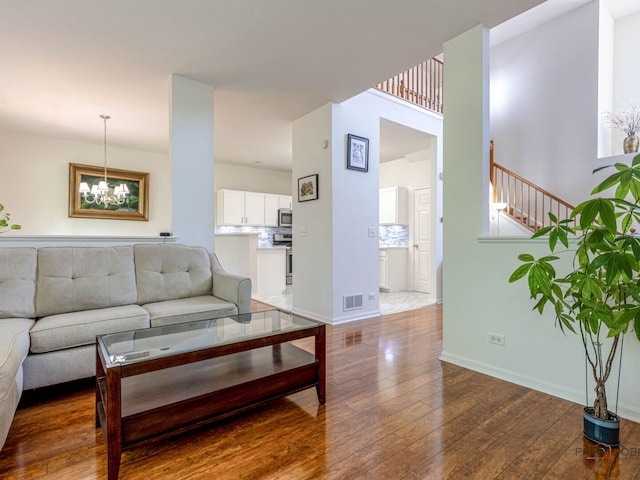 696 S Jade Ln, Round Lake, IL 60073 - living area featuring hardwood / wood-style flooring, a chandelier, and stairway
