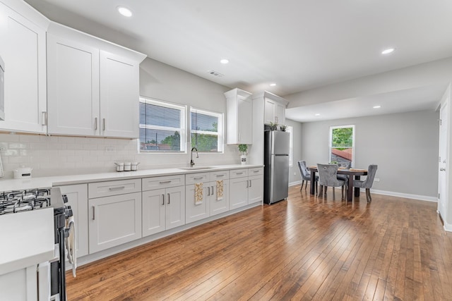 4438 S Knox Ave, Chicago, IL 60632 - kitchen with stainless steel appliances, tasteful backsplash, hardwood / wood-style floors, light countertops, and white cabinets