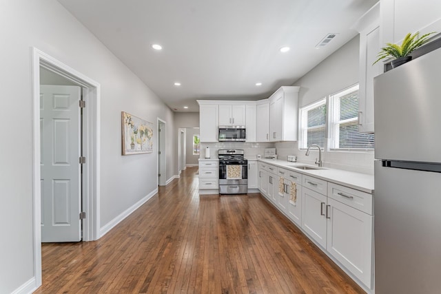 4438 S Knox Ave, Chicago, IL 60632 - kitchen with stainless steel appliances, white cabinets, tasteful backsplash, light countertops, and dark wood finished floors