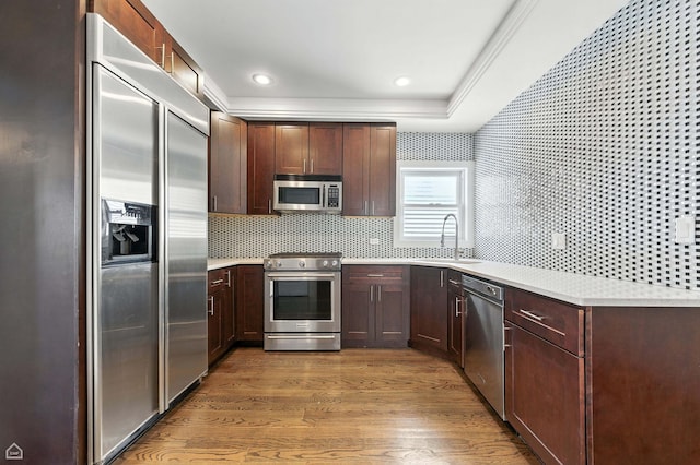 2314 N Mango Ave, Chicago, IL 60639 - kitchen with high end appliances, wood finished floors, light countertops, decorative backsplash, and recessed lighting