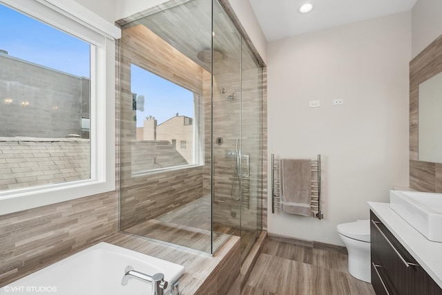1547 N Wood St Unit 2, Chicago, IL 60622 - full bath featuring vanity, a stall shower, a towel warming rack, a bath, and wood finished floors