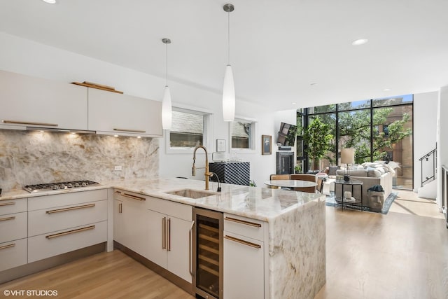 1547 N Wood St Unit 2, Chicago, IL 60622 - kitchen with wine cooler, stainless steel gas cooktop, light wood-type flooring, a peninsula, and tasteful backsplash