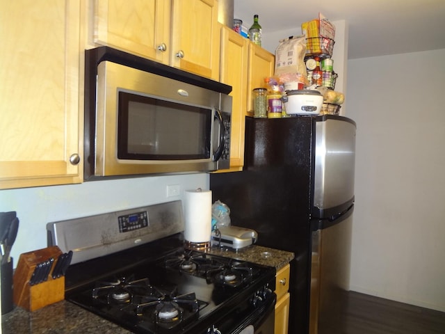 1931 Prairie Sq Unit 329, Schaumburg, IL 60173 - kitchen featuring stainless steel microwave, range with gas stovetop, dark wood-style flooring, and dark stone counters