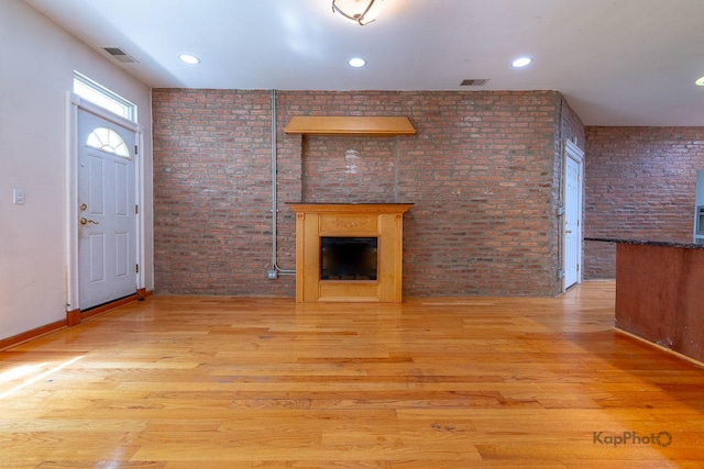 4137 S Prairie Ave Unit 3, Chicago, IL 60653 - unfurnished living room featuring brick wall, a fireplace, wood finished floors, and recessed lighting
