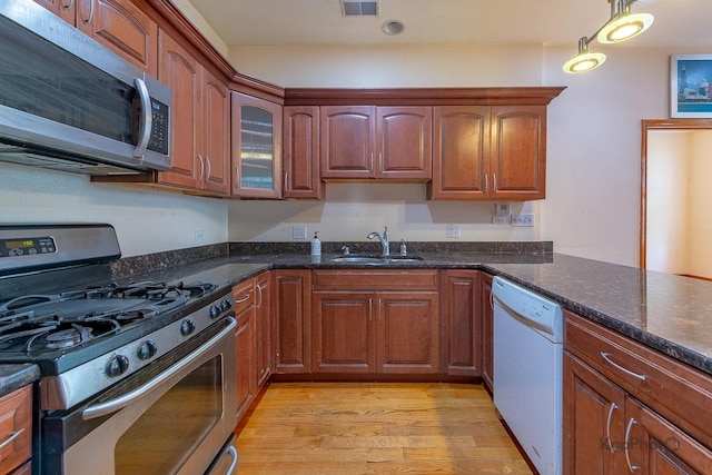 4137 S Prairie Ave Unit 3, Chicago, IL 60653 - kitchen with stainless steel appliances, light wood-type flooring, dark stone countertops, and pendant lighting