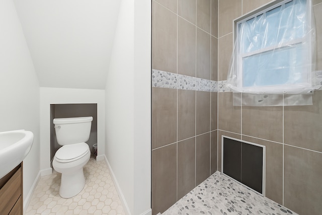 422 Locust St, Elgin, IL 60123 - full bathroom featuring a tile shower, vanity, vaulted ceiling, and tile patterned flooring