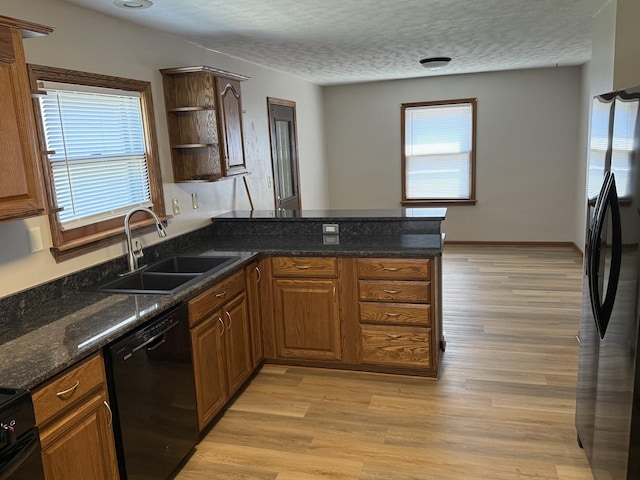 602 River Ln, Loves Park, IL 61111 - kitchen featuring black dishwasher, freestanding refrigerator, a peninsula, light wood-style flooring, and a textured ceiling