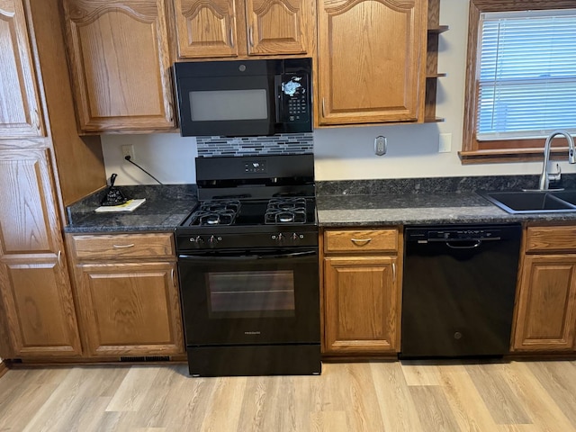 602 River Ln, Loves Park, IL 61111 - kitchen with black appliances, light wood-style flooring, open shelves, dark stone countertops, and brown cabinetry