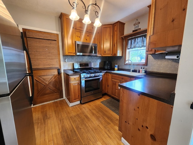 661 S Swain Ave, Elmhurst, IL 60126 - kitchen with appliances with stainless steel finishes, dark countertops, light wood-style flooring, and a chandelier