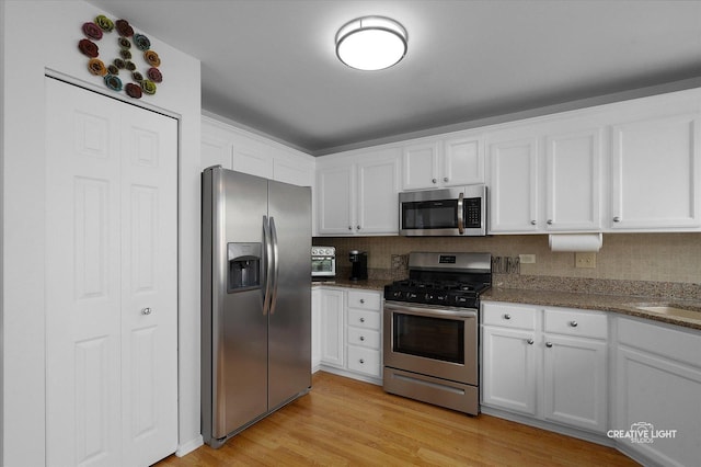25 Cedar Ct, South Elgin, IL 60177 - kitchen with stainless steel appliances, white cabinets, light wood finished floors, and dark stone counters