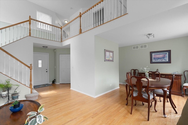 25 Cedar Ct, South Elgin, IL 60177 - dining space featuring light wood-type flooring, stairs, and a towering ceiling