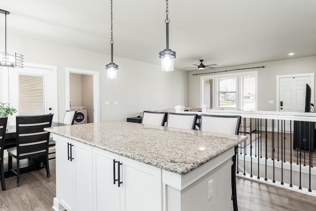 650 Anacostia Dr, Roscoe, IL 61073 - kitchen featuring washer / dryer, ceiling fan, light wood-style flooring, a center island, and hanging light fixtures