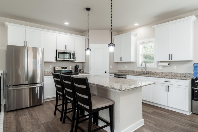 650 Anacostia Dr, Roscoe, IL 61073 - kitchen featuring appliances with stainless steel finishes, a kitchen island, dark wood-style flooring, white cabinets, and recessed lighting