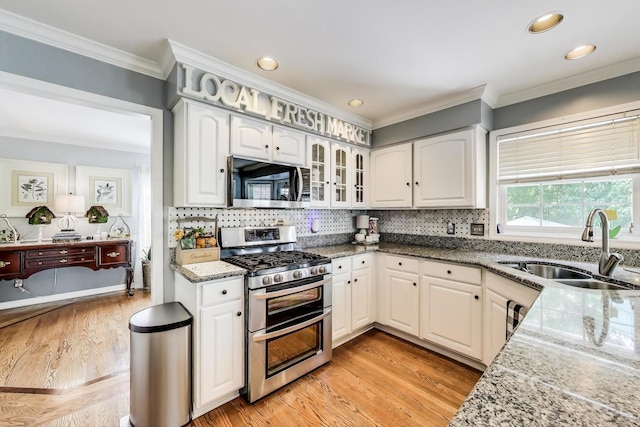 346 Colonial Cir, Geneva, IL 60134 - kitchen with appliances with stainless steel finishes, light stone counters, light wood-style flooring, tasteful backsplash, and glass insert cabinets