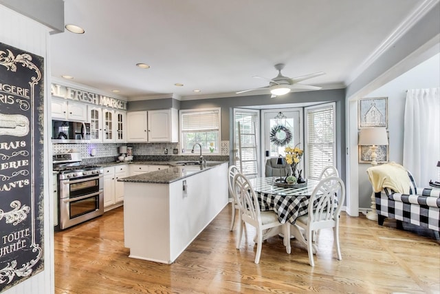 346 Colonial Cir, Geneva, IL 60134 - kitchen with stainless steel appliances, crown molding, a peninsula, glass insert cabinets, and a ceiling fan