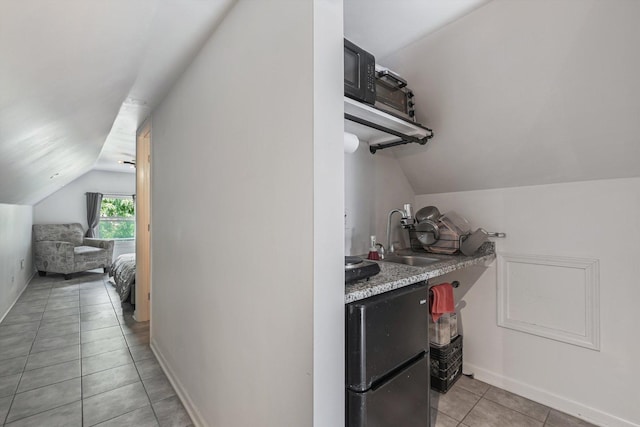 2630 S Spaulding Ave, Chicago, IL 60623 - kitchen featuring vaulted ceiling, light tile patterned floors, and light countertops