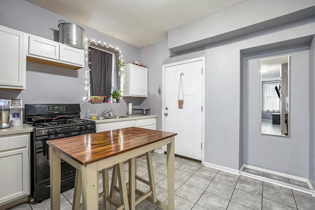2630 S Spaulding Ave, Chicago, IL 60623 - kitchen featuring black gas range, light countertops, white cabinetry, and light tile patterned flooring