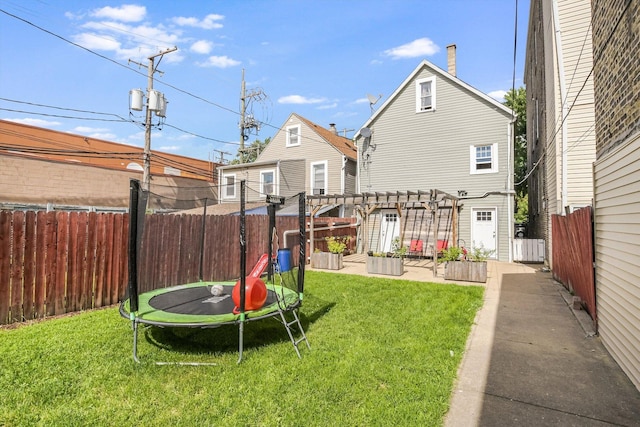 2630 S Spaulding Ave, Chicago, IL 60623 - rear view of house with a trampoline, a pergola, a fenced backyard, and a vegetable garden