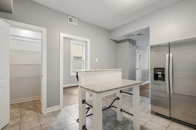 2630 S Spaulding Ave, Chicago, IL 60623 - kitchen with stainless steel refrigerator with ice dispenser, light tile patterned floors, and light countertops