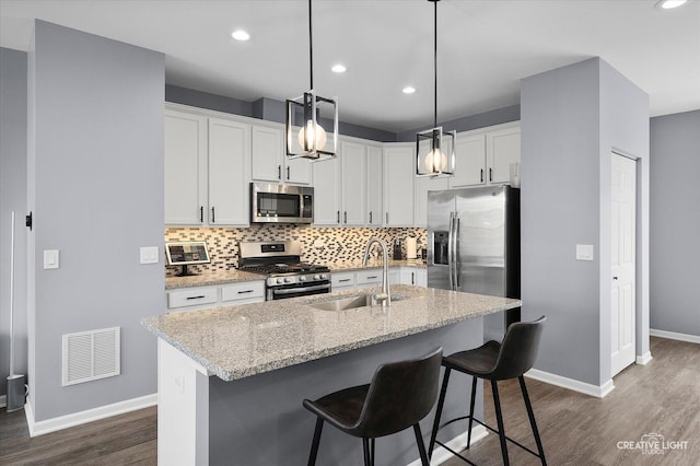 875 Finley Dr, Aurora, IL 60504 - kitchen with stainless steel appliances, dark wood finished floors, backsplash, white cabinets, and recessed lighting