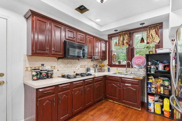 512 Ryerson Ave, Elgin, IL 60123 - kitchen with black microwave, light countertops, gas stovetop, dark wood finished floors, and backsplash