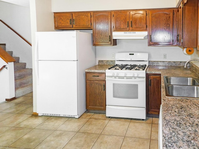 6059 Durrington Dr, Loves Park, IL 61111 - kitchen with white appliances, under cabinet range hood, light tile patterned floors, and brown cabinetry