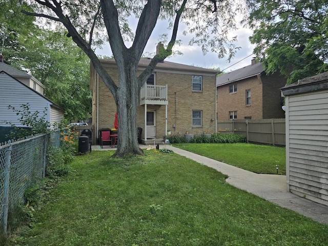 1524 Greenwood Ave, Rockford, IL 61107 - rear view of house with a fenced backyard, brick siding, and a balcony