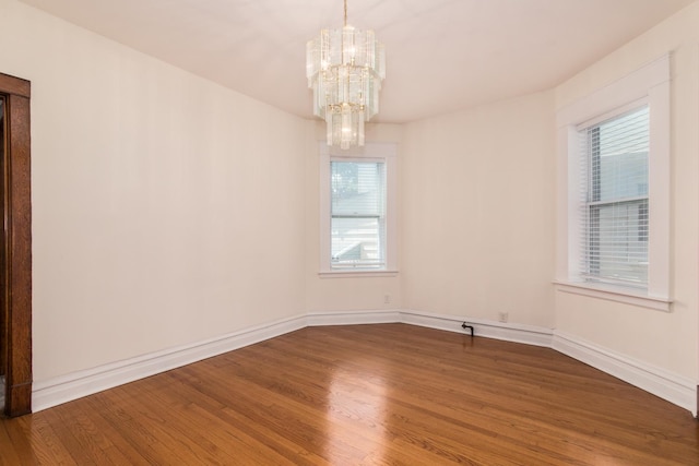 3029 N Haussen Ct, Chicago, IL 60618 - unfurnished room featuring a chandelier, wood finished floors, and plenty of natural light