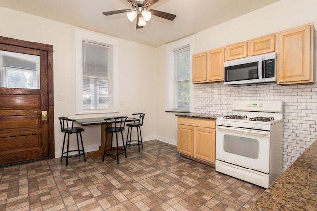 3029 N Haussen Ct, Chicago, IL 60618 - kitchen featuring white gas range, light brown cabinetry, decorative backsplash, and brick patterned flooring