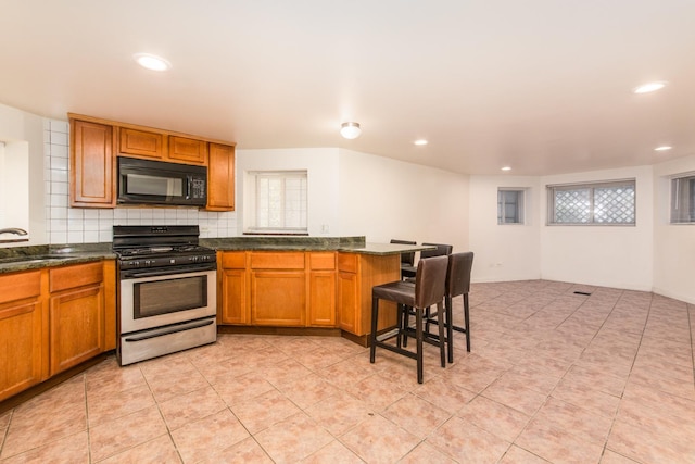 3029 N Haussen Ct, Chicago, IL 60618 - kitchen featuring black microwave, gas range, brown cabinets, backsplash, and recessed lighting