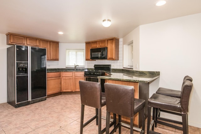 3029 N Haussen Ct, Chicago, IL 60618 - kitchen featuring black appliances, tasteful backsplash, a peninsula, recessed lighting, and brown cabinetry