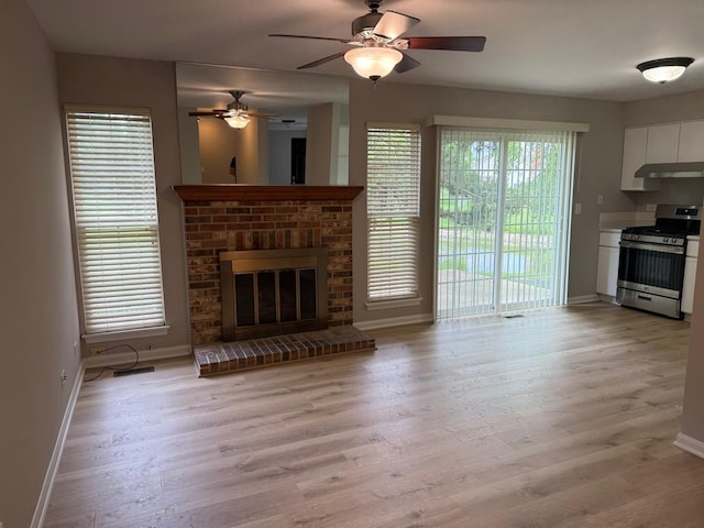 36138 N Springbrook Ln Unit 36138, Gurnee, IL 60031 - unfurnished living room featuring light wood-type flooring, a brick fireplace, and ceiling fan