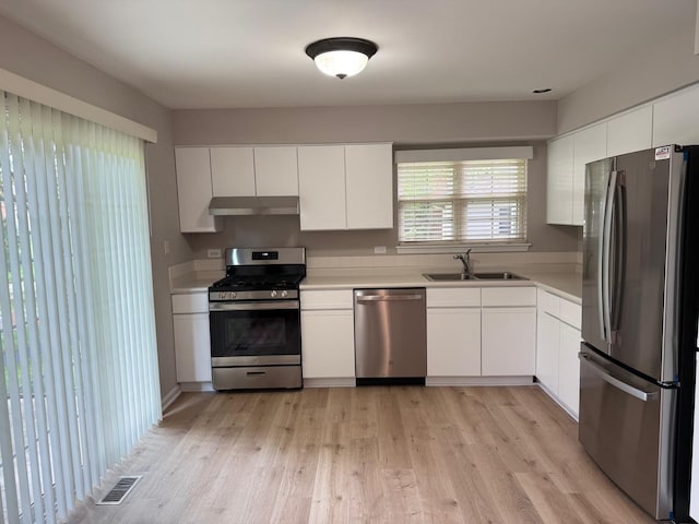 36138 N Springbrook Ln Unit 36138, Gurnee, IL 60031 - kitchen featuring appliances with stainless steel finishes, under cabinet range hood, light countertops, and white cabinetry