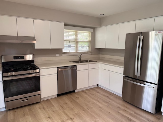 36138 N Springbrook Ln Unit 36138, Gurnee, IL 60031 - kitchen with appliances with stainless steel finishes, under cabinet range hood, light countertops, white cabinetry, and light wood-type flooring