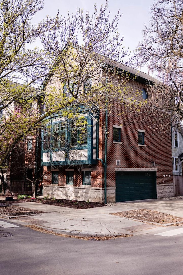 3056 N Paulina St, Chicago, IL 60657 - view of front of house with concrete driveway, brick siding, and a garage
