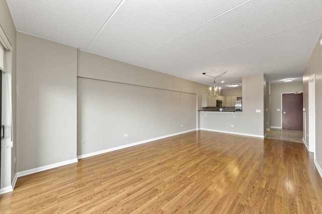 6420 Double Eagle Dr Unit 510, Woodridge, IL 60517 - unfurnished living room featuring a chandelier, light wood finished floors, and a textured ceiling